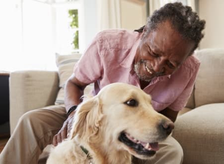 Happy senior man petting his dog.