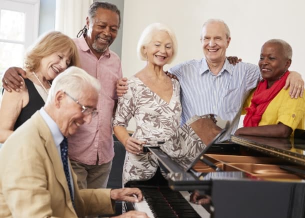 People gathered around a piano socializing.