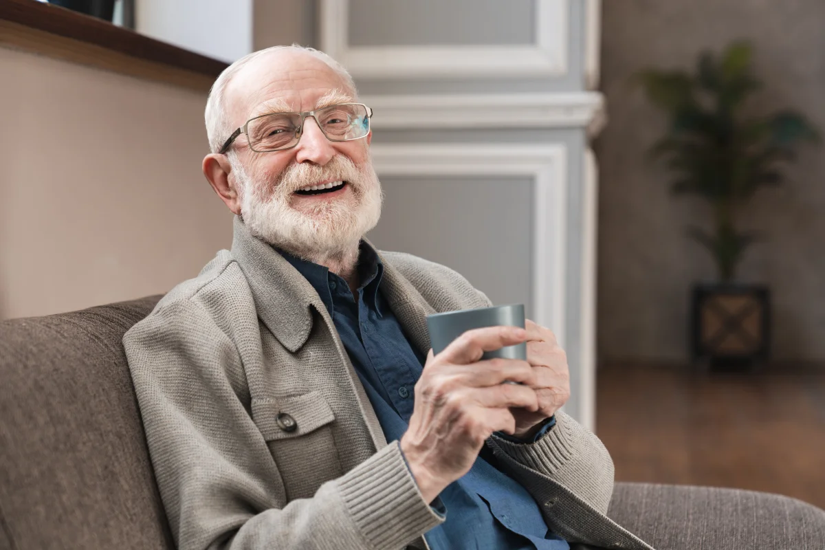 elderly man with glasses enjoying a warm cup of coffee