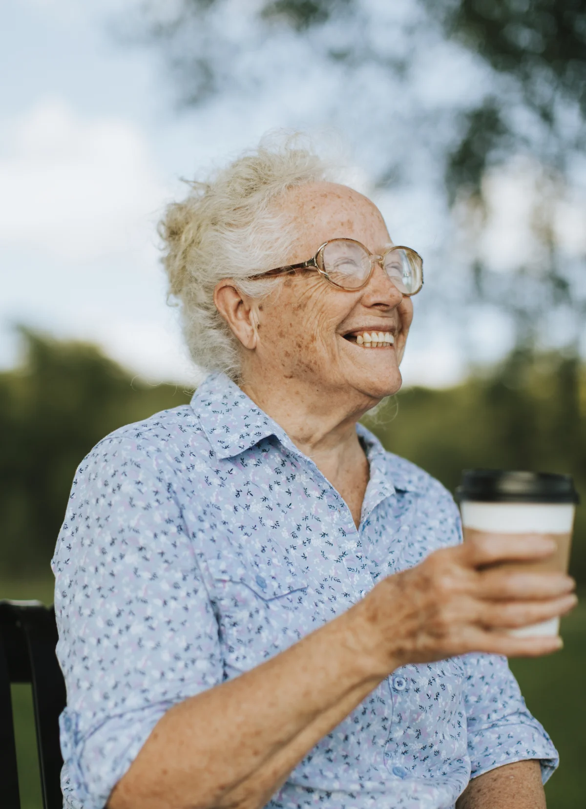 happy senior woman enjoying a coffee in the community courtyard