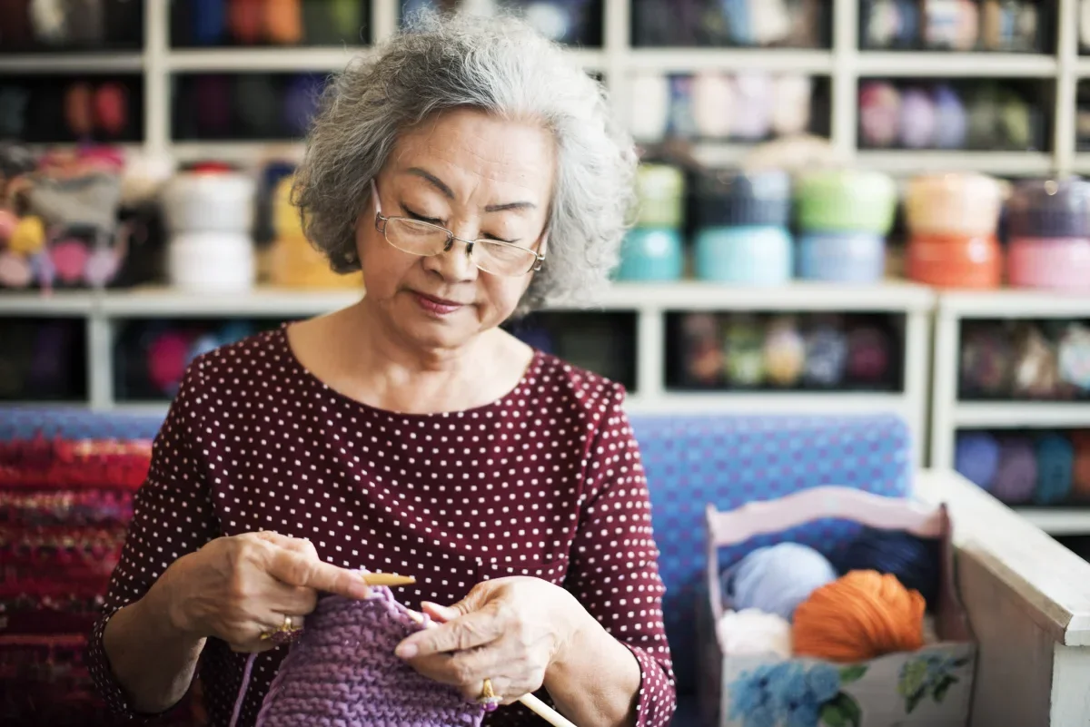 senior woman knitting in the community activity room