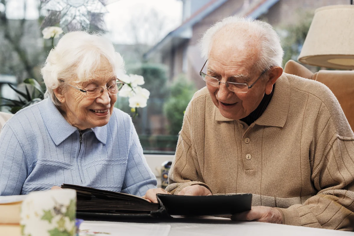 senior couple looking at old photographs together
