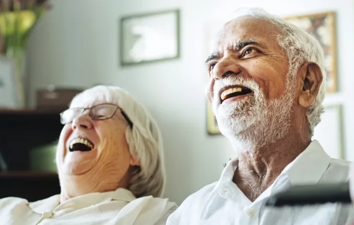 group of senior friends watching television together on couch