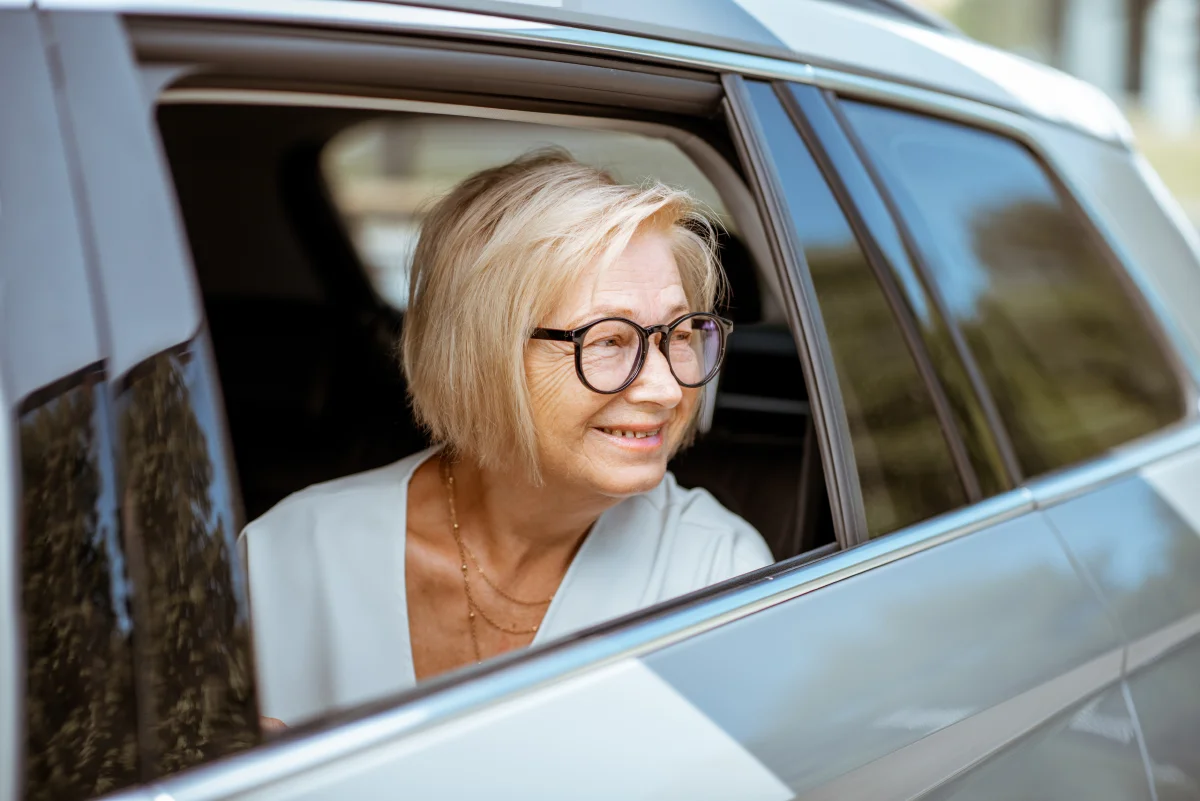 senior woman in the backseat of car looking out the window