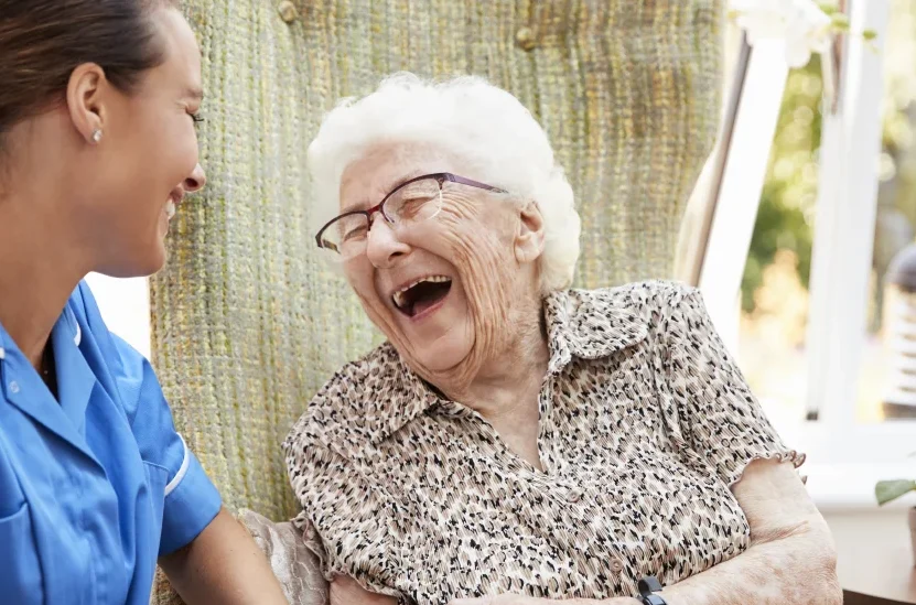 senior woman laughing with nurse